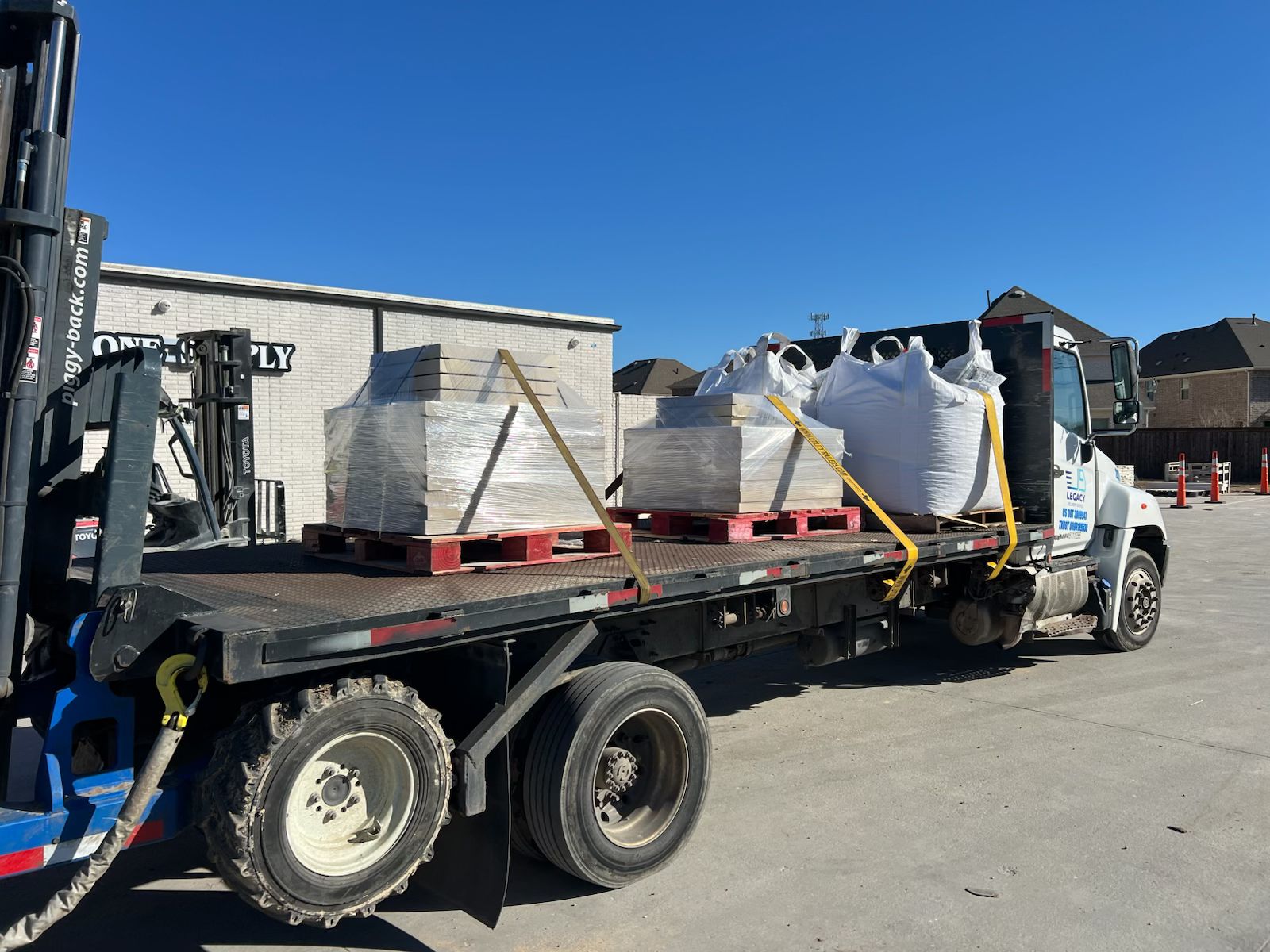 Heavy-duty truck unloading stone at a Dallas construction site